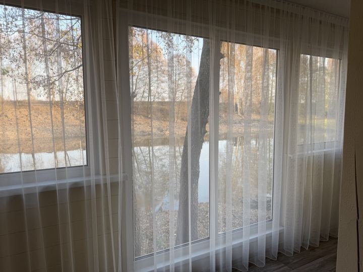 Вид из панорамного окна домика на реку